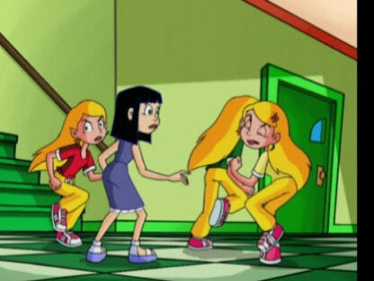 Three girls in a classroom hallway, two blondes in yellow pants confront a dark-haired girl in a blue dress, grabbing her arm in a tense moment.