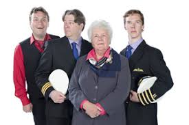 Four people posing: two young men in captain uniforms on the ends, a suited man holding a white cap, and an elderly woman in a scarf.